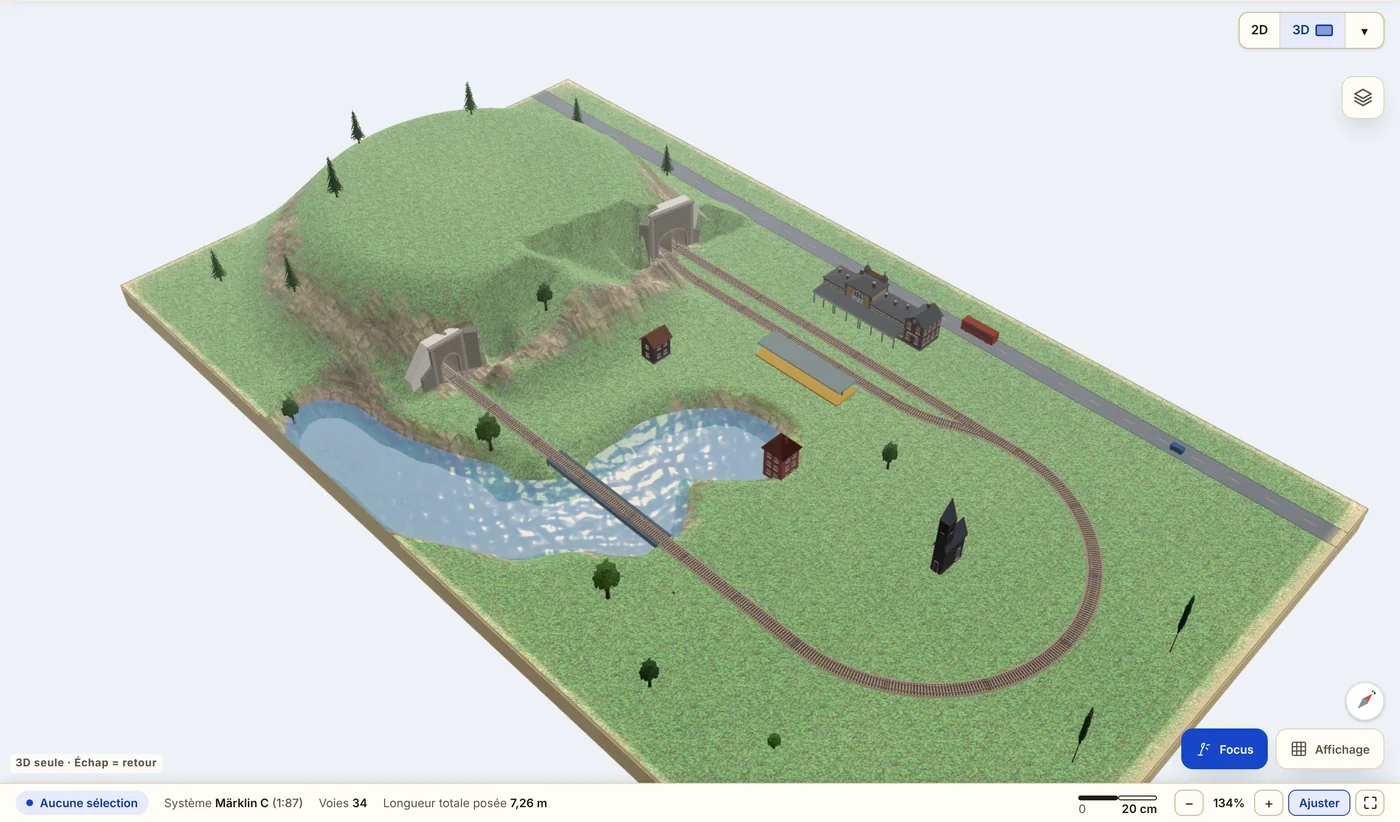 Le même réseau en vue 3D : la voie passe dans un tunnel sous la colline et sur un pont au-dessus d’un ruisseau, avec la gare, une route, des maisons et des arbres sur l’herbe.